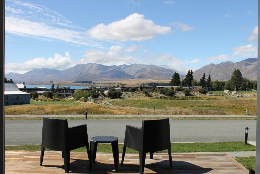 two chairs and a stool in front of a road at Queenie's Lakeview Star in Lake Tekapo