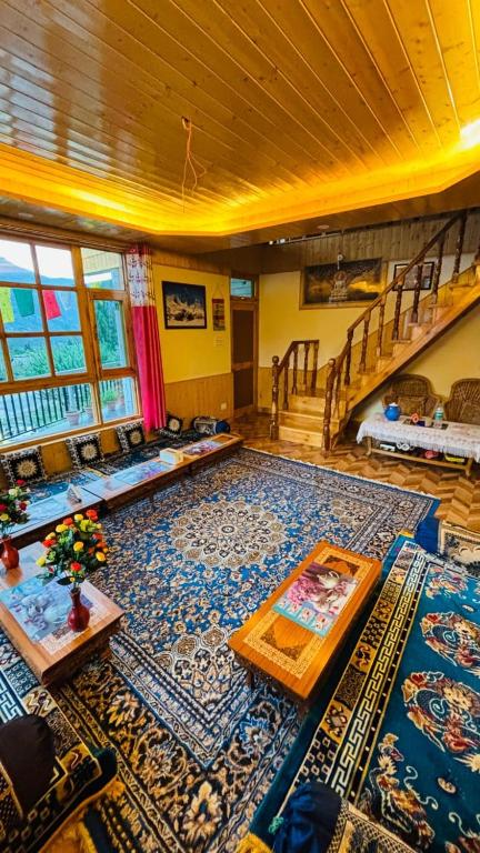 a large living room with a large rug at Ghar Homestay in Kulu