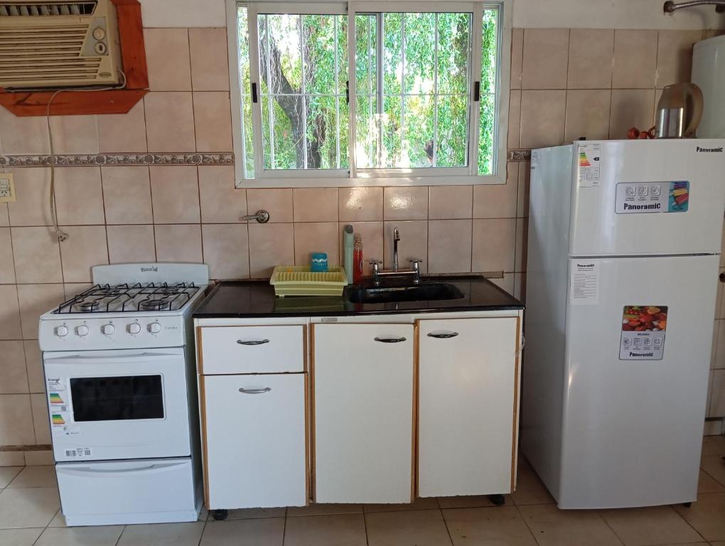 eine Küche mit weißen Geräten und einem weißen Kühlschrank in der Unterkunft Casa Las Marías in General Belgrano