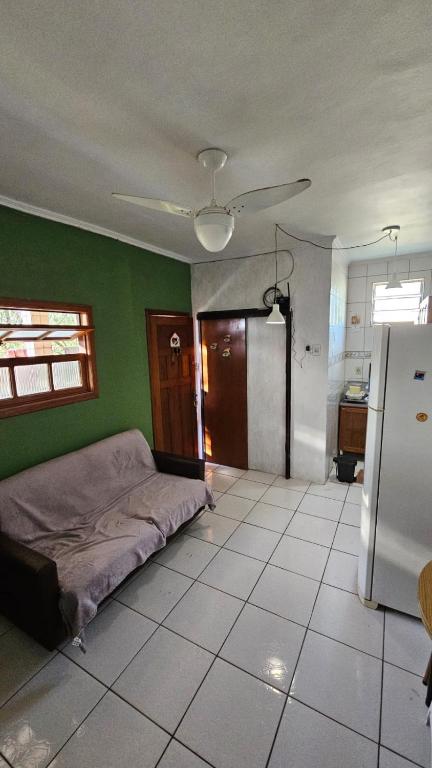 ein Schlafzimmer mit einem Bett und einer grünen Wand in der Unterkunft Apartamento de 1 quarto próximo a praia - Com Estacionamento Rotativo in Tramandaí