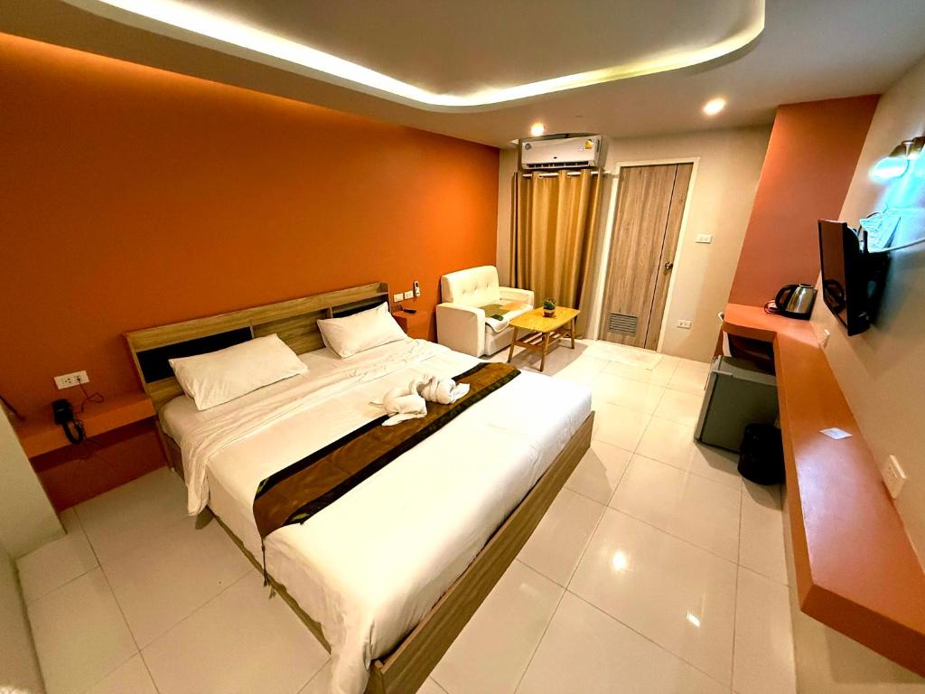 une chambre avec un grand lit et une télévision dans l'établissement THE NICE, à Patong Beach