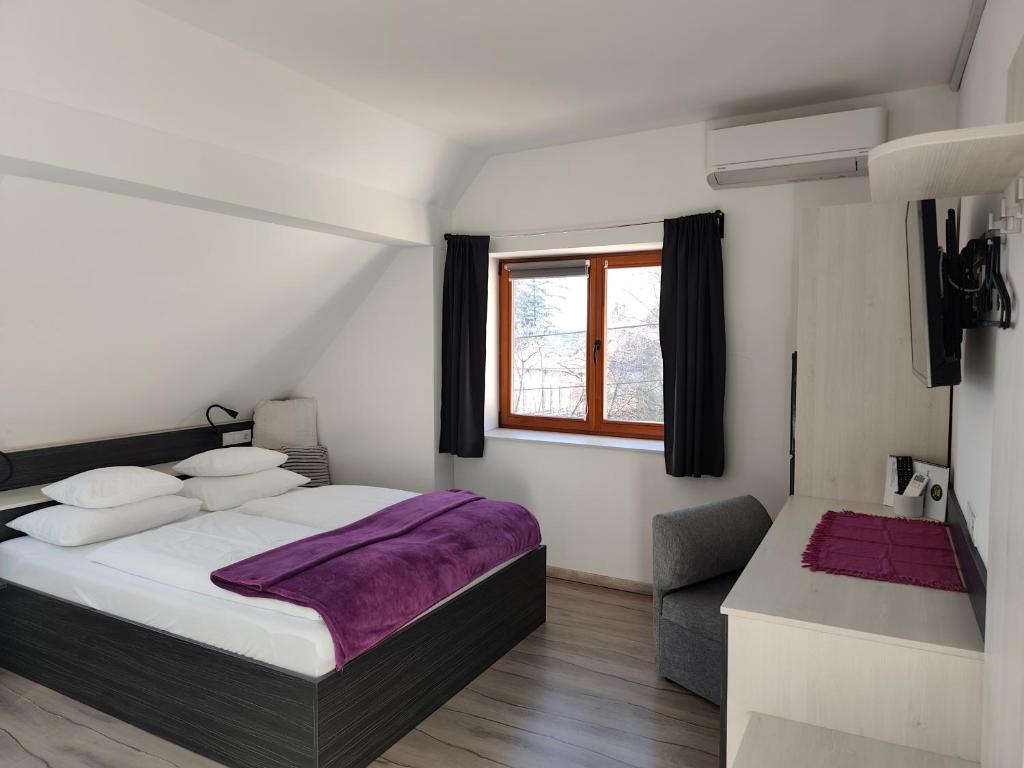 a bedroom with a bed and a window and a couch at Darázshegyi Panzió és Faházak - Panzió épület in Mátraszentimre