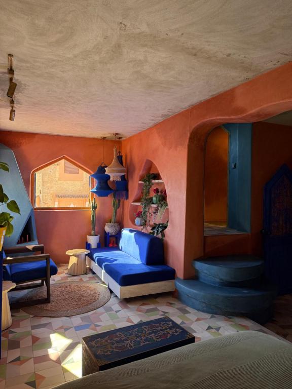 una camera con letto blu e pareti arancioni di Casa Amina a Chefchaouen