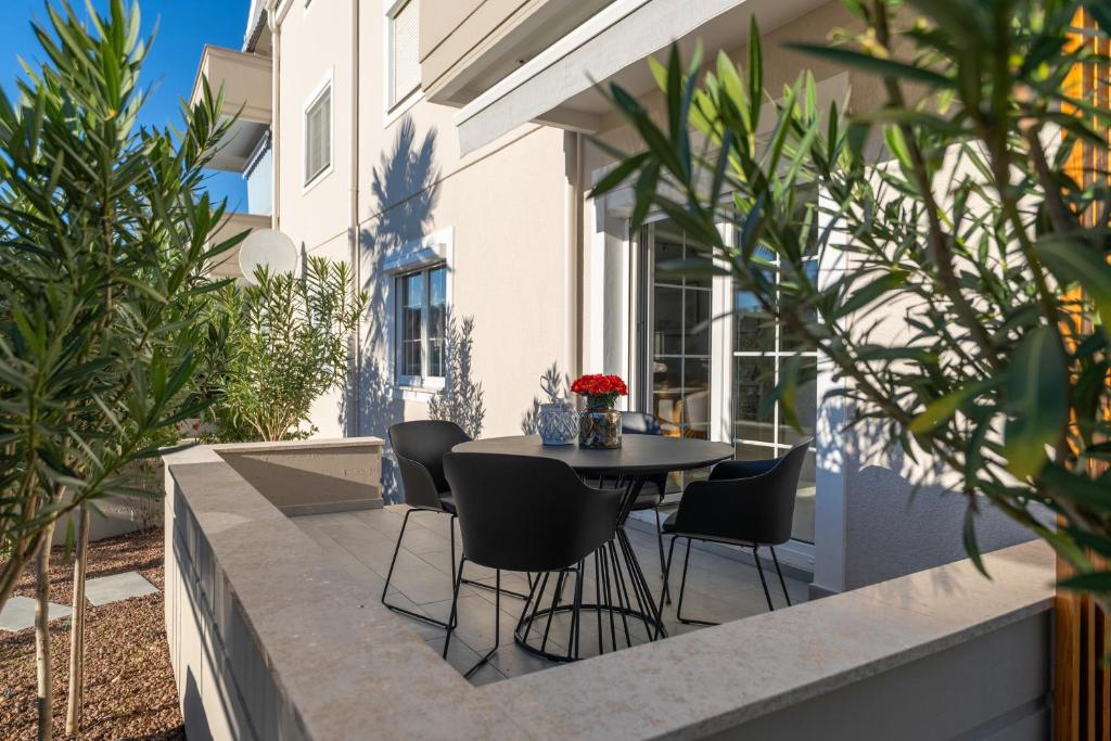 een terras met een tafel en stoelen op een balkon bij Apartment Sara Premium in Funtana