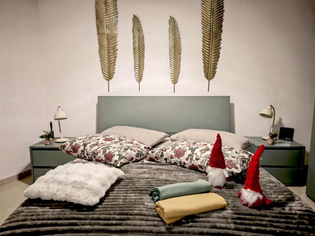 锡拉库扎Ortigia Domus的卧室里，床上放着两顶圣诞帽和几个枕头。