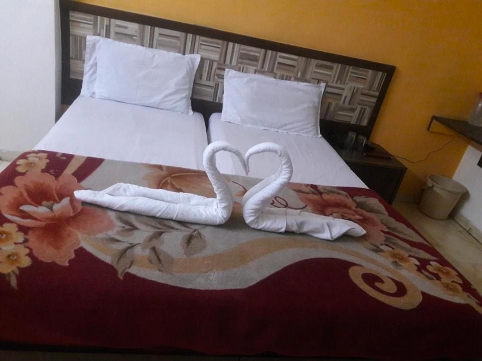 纳西克Hotel Saffronn的两个天鹅 ⁇ 地想着他们正在床上吻