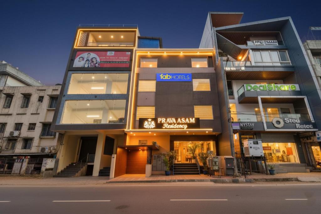 斋浦尔FabHotel Pravaasam Residency的夜晚城市街道上的一栋建筑