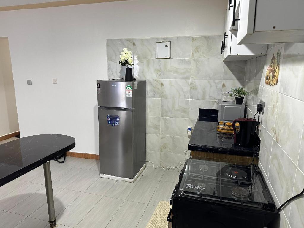 a kitchen with a stainless steel refrigerator in the corner at Galaxy Suites Meru in Meru