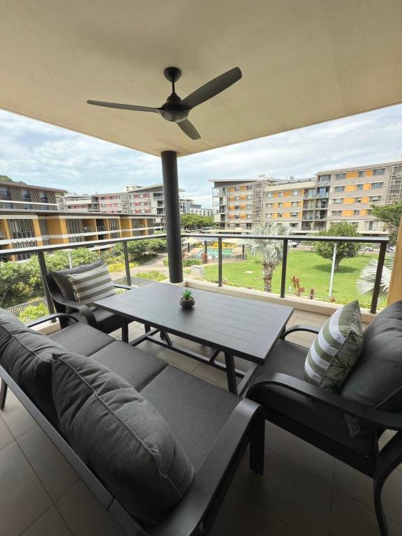 a balcony with couches and a table with a ceiling fan at The Palms at Waterfront in Darwin