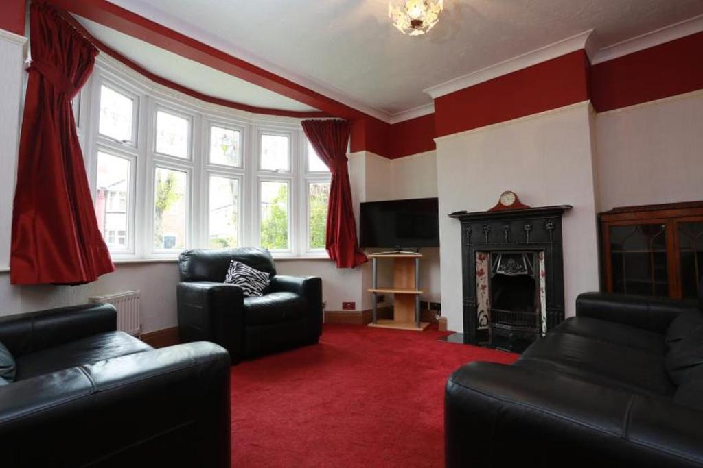 a living room with two couches and a fireplace at Bournemouth Holiday Home in Southbourne
