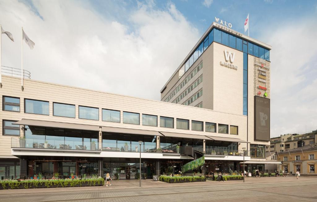 a large building with people walking in front of it at Original Sokos Hotel Wiklund in Turku
