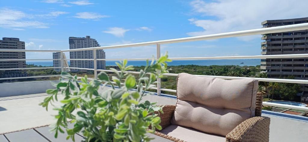 een stoel op een balkon met uitzicht op de stad bij Chillis Penthouse in Porlamar
