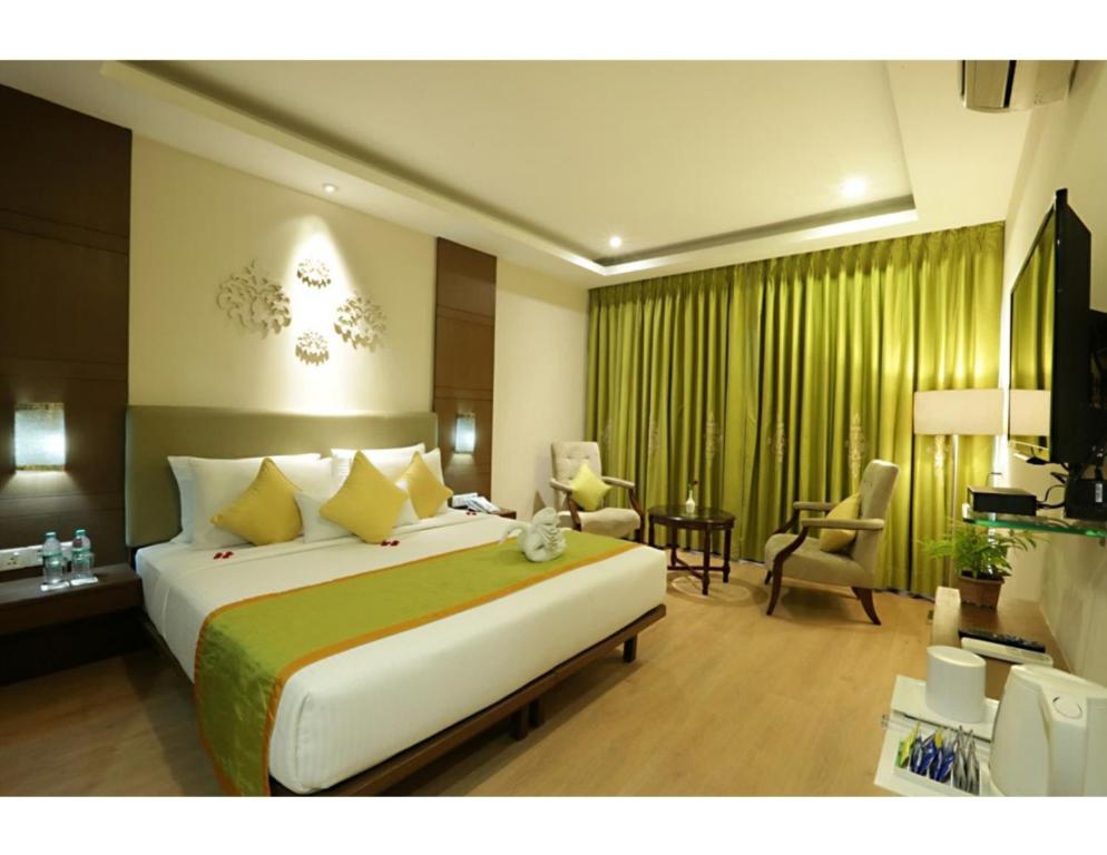 a bedroom with a large bed and a living room at Airport Hotel Paragon Suites Delhi Airport in New Delhi