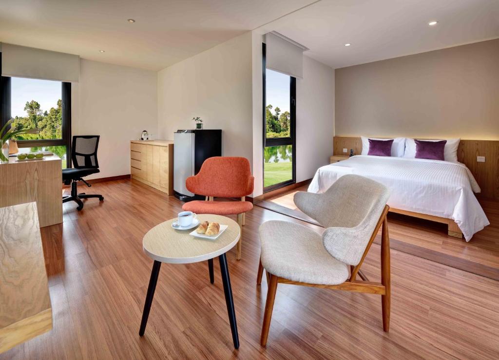 a bedroom with a bed and a table and chairs at Lakeview Terrace Resort Pengerang in Pengerang