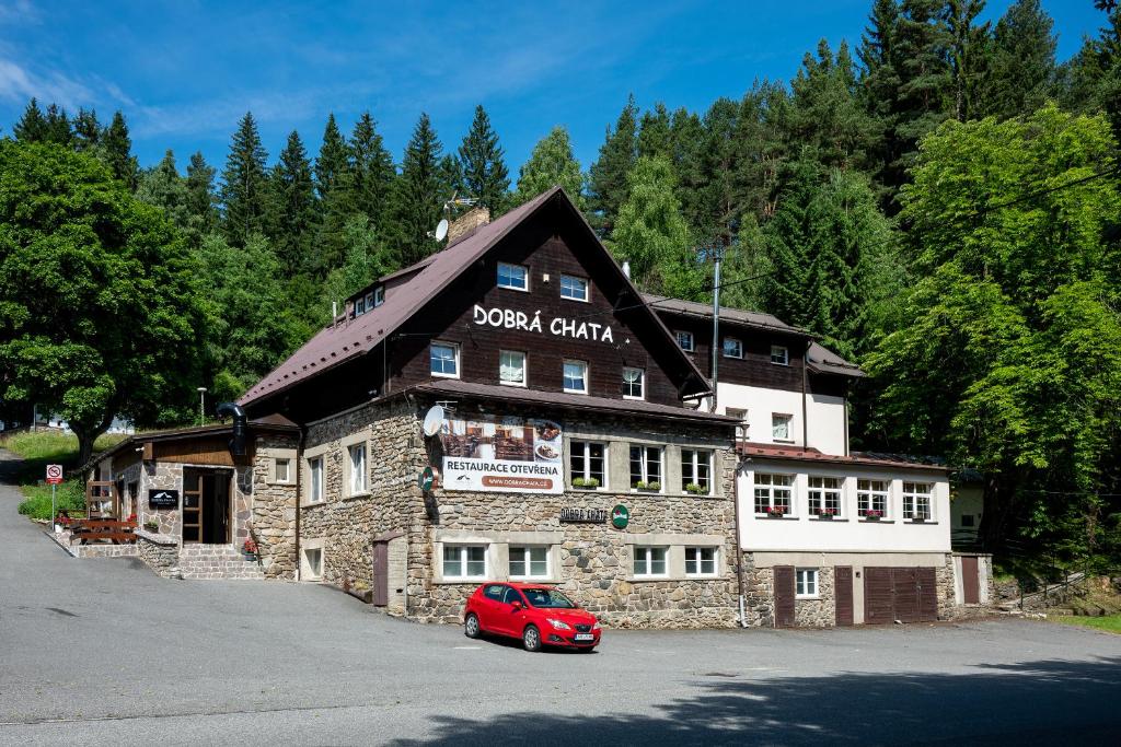 Stachy优度假日大酒店的一辆红色汽车停在一栋建筑物前