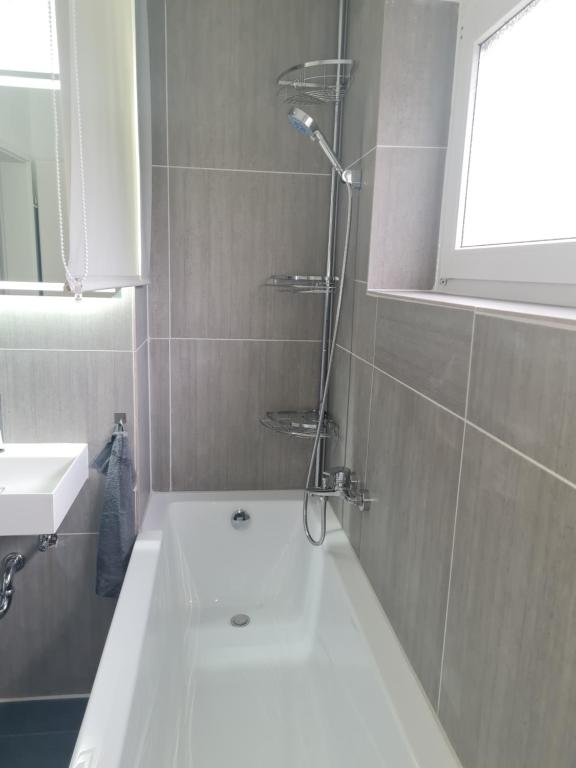 un baño con bañera y lavabo en Zimmer-Leutkirch, en Leutkirch im Allgäu