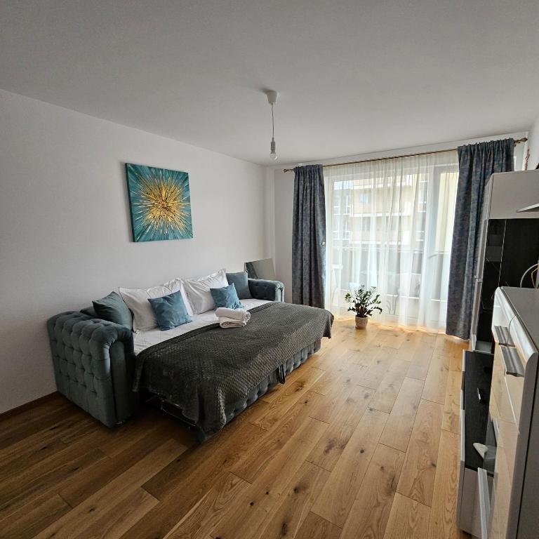 a living room with a couch and a large window at FourSeasons Residence in Braşov