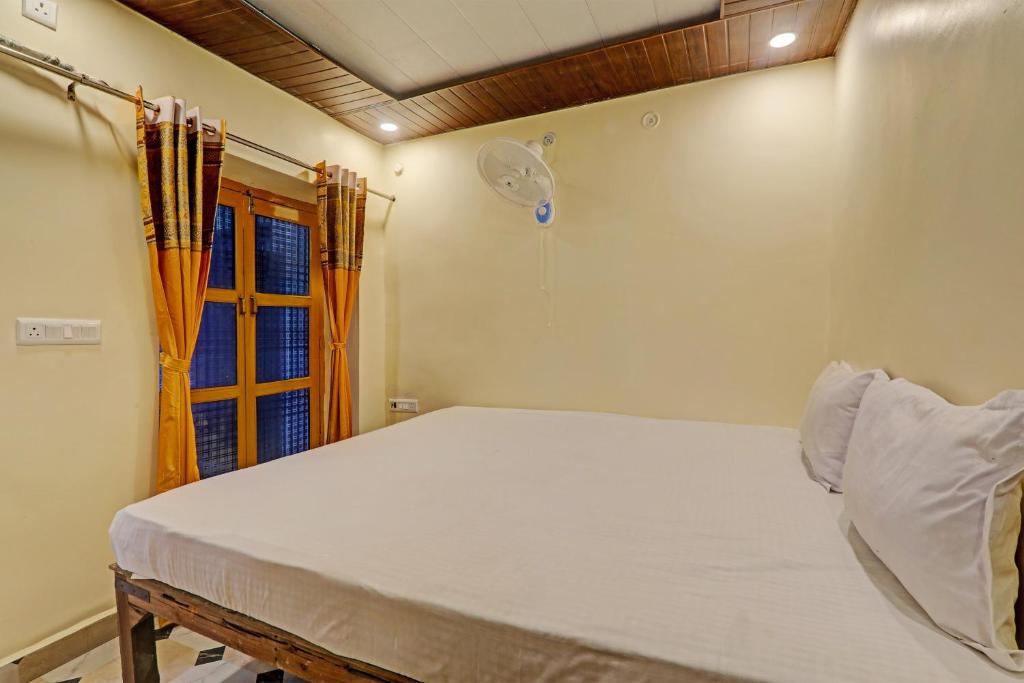 een slaapkamer met een groot wit bed met een raam bij Hotel O Home Shyama Lodge in Ayodhya