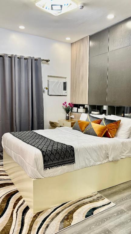 une chambre avec un grand lit dans une pièce dans l'établissement AMANI GRAND CITYGATE STUDIO by ADORE IT, à Davao