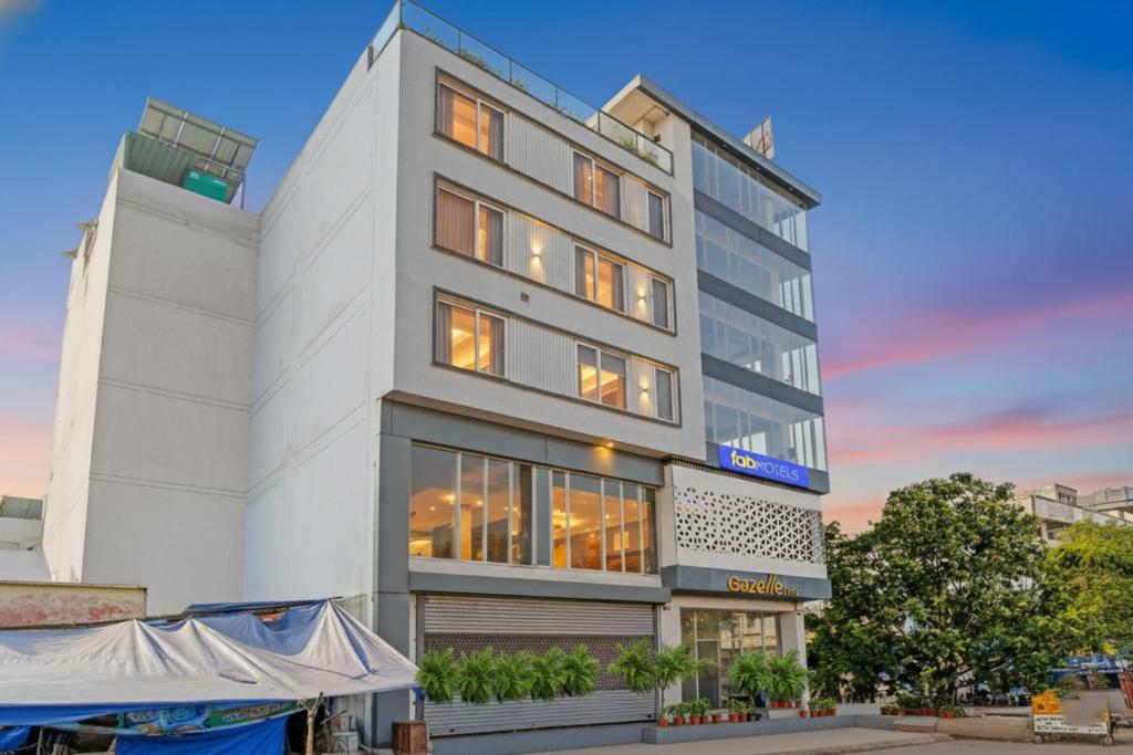 um prédio alto e branco com muitas janelas em FabHotel Gazelle Inn em Gurgaon