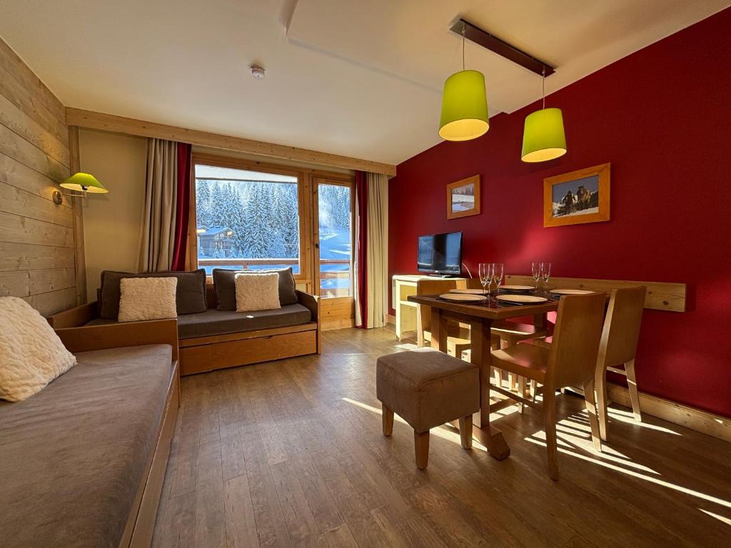 a living room with a room with a table and a couch at Résidence Christiana 406 Clés Blanches Courchevel in La Tania