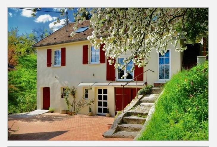 施瓦格明德Haus Haselmaus - Zaunkönig的白色的房子,有红色百叶窗和一棵树