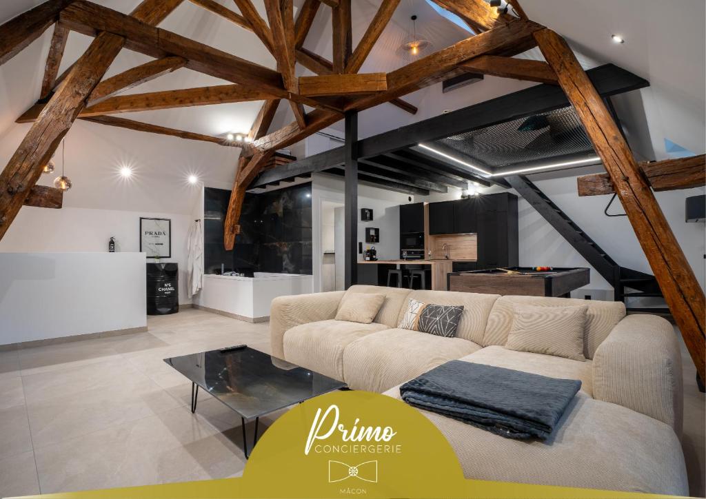 BuxyLe Saint-André - Clim - Loft romantique avec Jacuzzi - By Primo的客厅里有一张沙发和一张桌子。