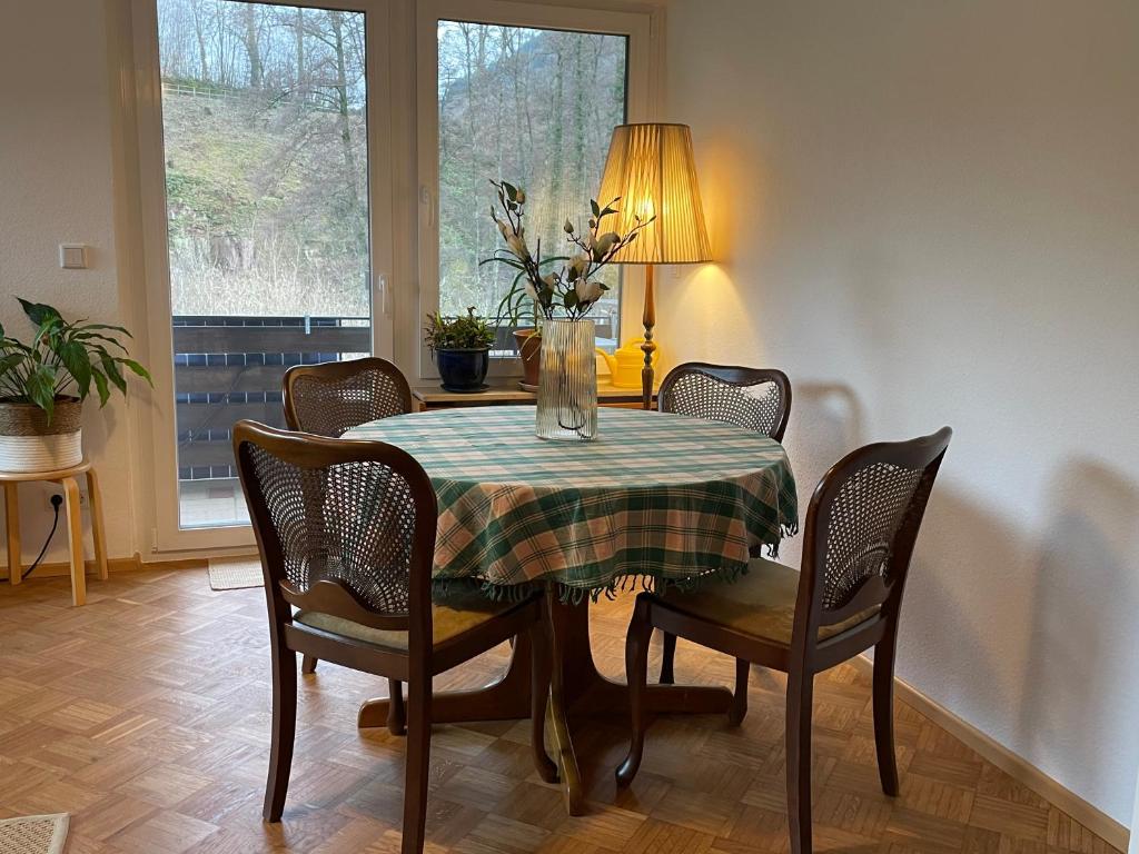 a dining room table with chairs and a vase of flowers on it at Das Grüne Nest in Neckarsteinach