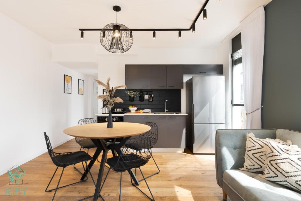 une cuisine et un salon avec une table et un canapé dans l'établissement CARMEL MARKET - Exclusive Collection - By HOMY, à Tel Aviv
