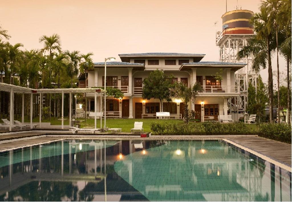 a house with a swimming pool in front of it at Myanmar Life Hotel in Yangon