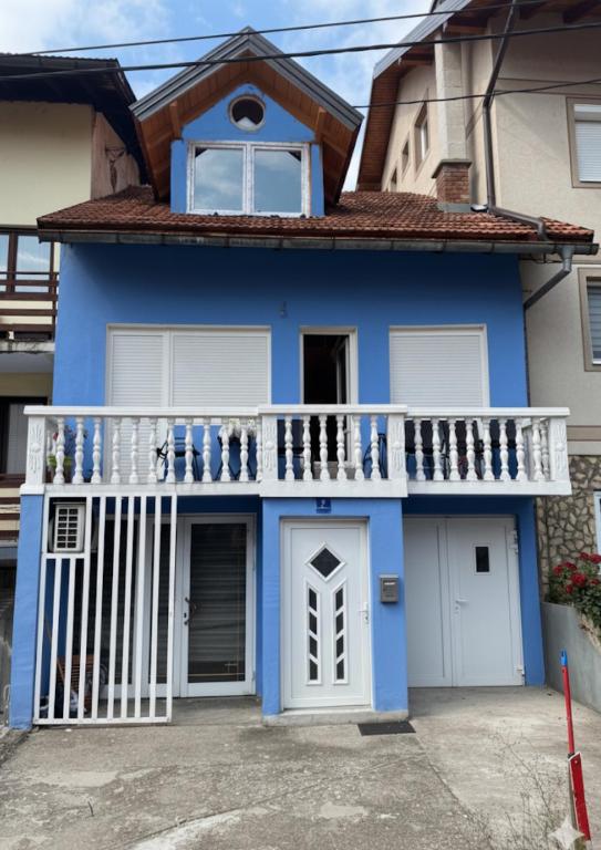 a blue house with a white balcony at MM Apartman in Foča
