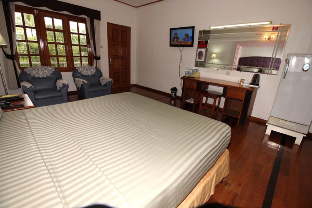 una camera con letto, scrivania e lavandino di Myanmar Life Hotel a Yangon
