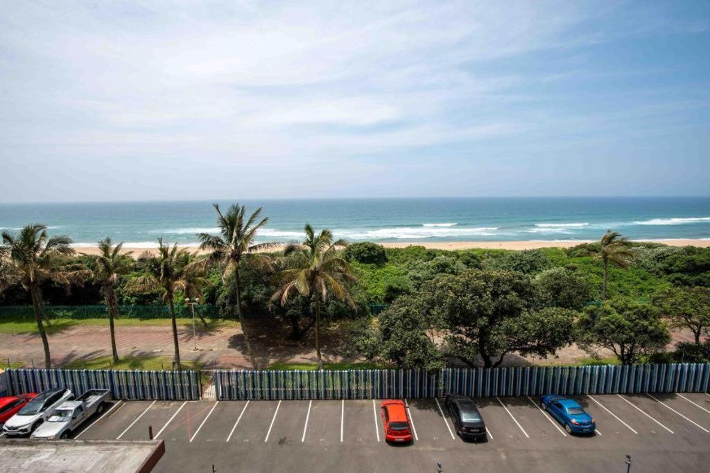 a group of cars parked in a parking lot near the beach at Beach Retreat in Amanzimtoti