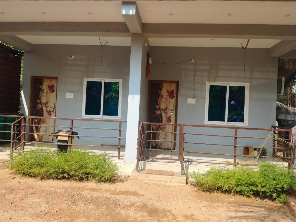 a building with two windows and a fence at Aasare Home Stay Gokarna in Kumta