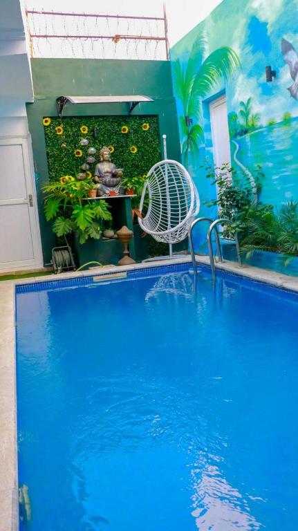 a blue swimming pool with a white chair next to it at Onzo Yamy in Luanda