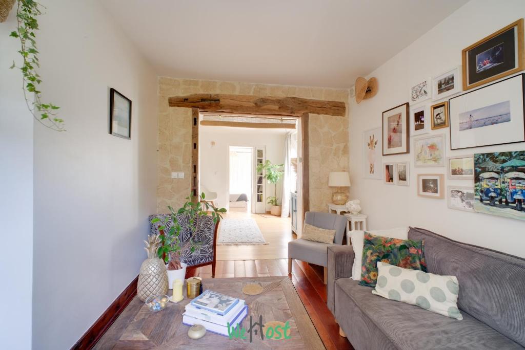 a living room with a couch and a table at Orves - Seine-Saint-Denis - CI - Elegance and comfort with garden for 2 people in Le Pré-Saint-Gervais