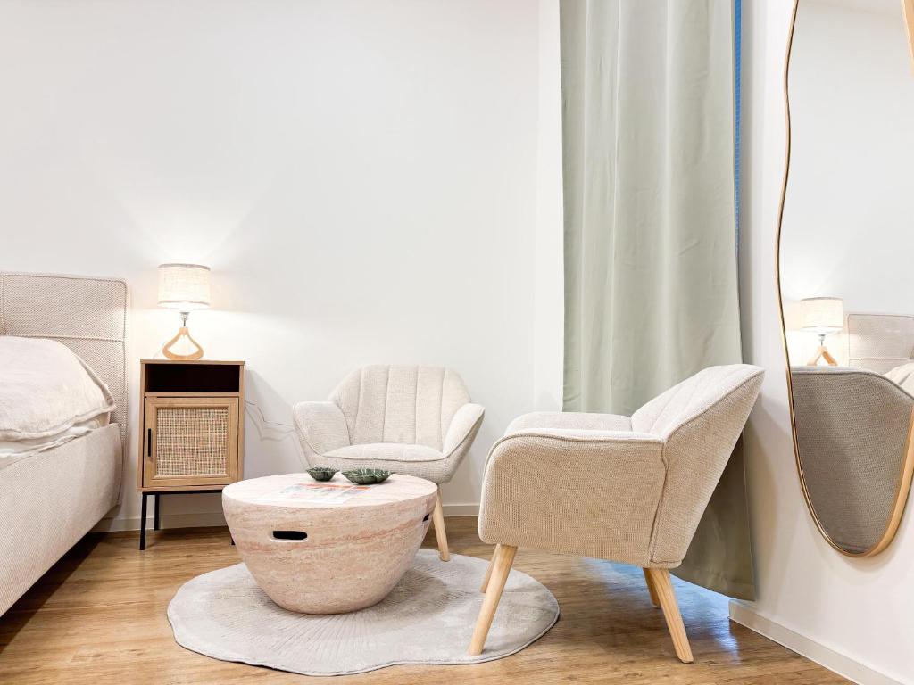 维也纳GG Immobilien-15 min to city centre的卧室配有两把椅子、一张桌子和一张床