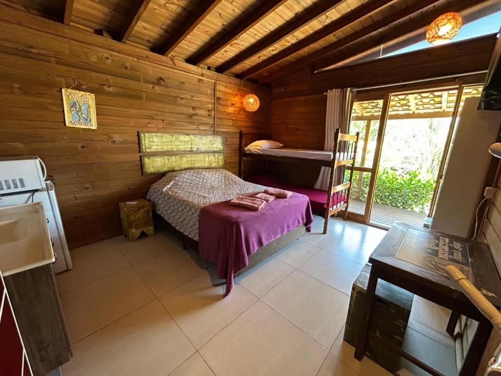um quarto com uma cama em uma cabana de madeira em Cabanas de Marina em Imbituba