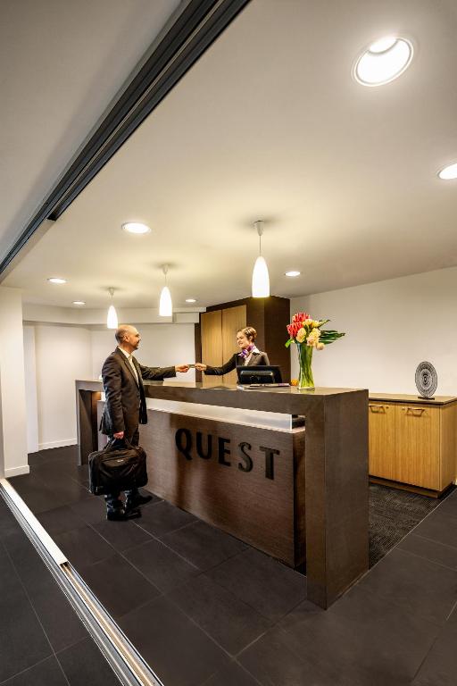 two men in an office with a post office at Quest Mounts Bay Road in Perth