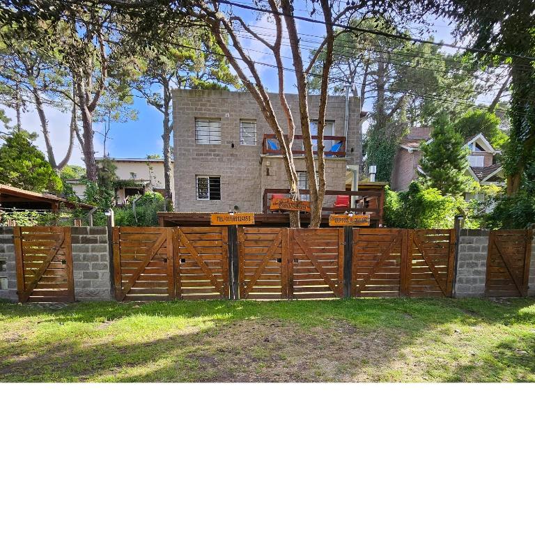 een houten hek voor een huis bij Gorriones Libres in Villa Gesell