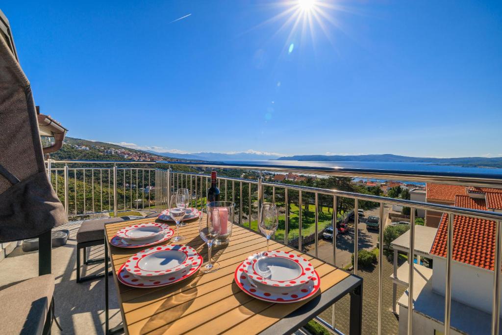 ein Tisch auf einem Balkon mit Blick auf das Meer in der Unterkunft Apartments Sunshine D in Crikvenica