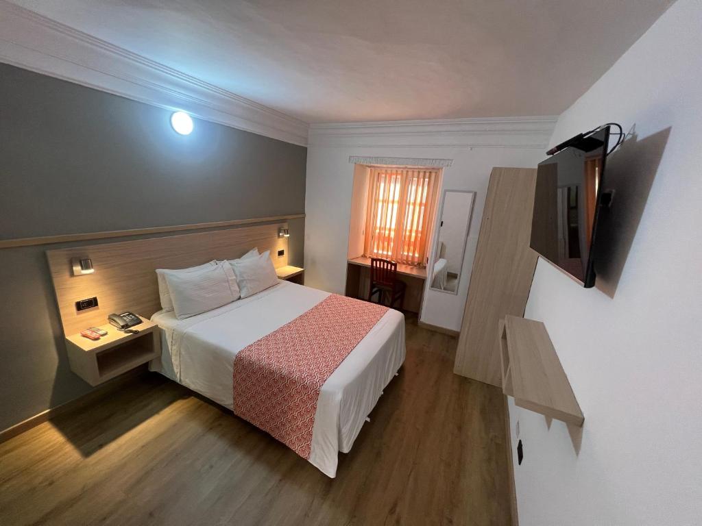 una habitación de hotel con una cama y un televisor en Hotel Cacique Real, en Zipaquirá