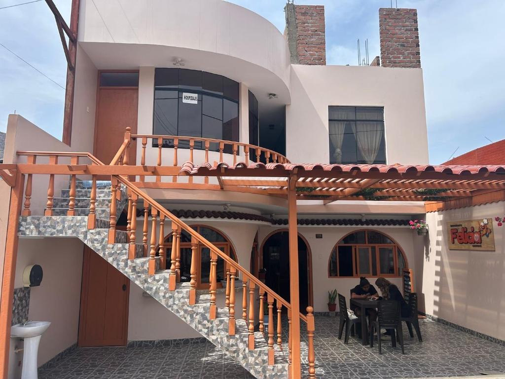 ルナウアナにあるHospedaje Cesarの家の前のテーブルに座る二人