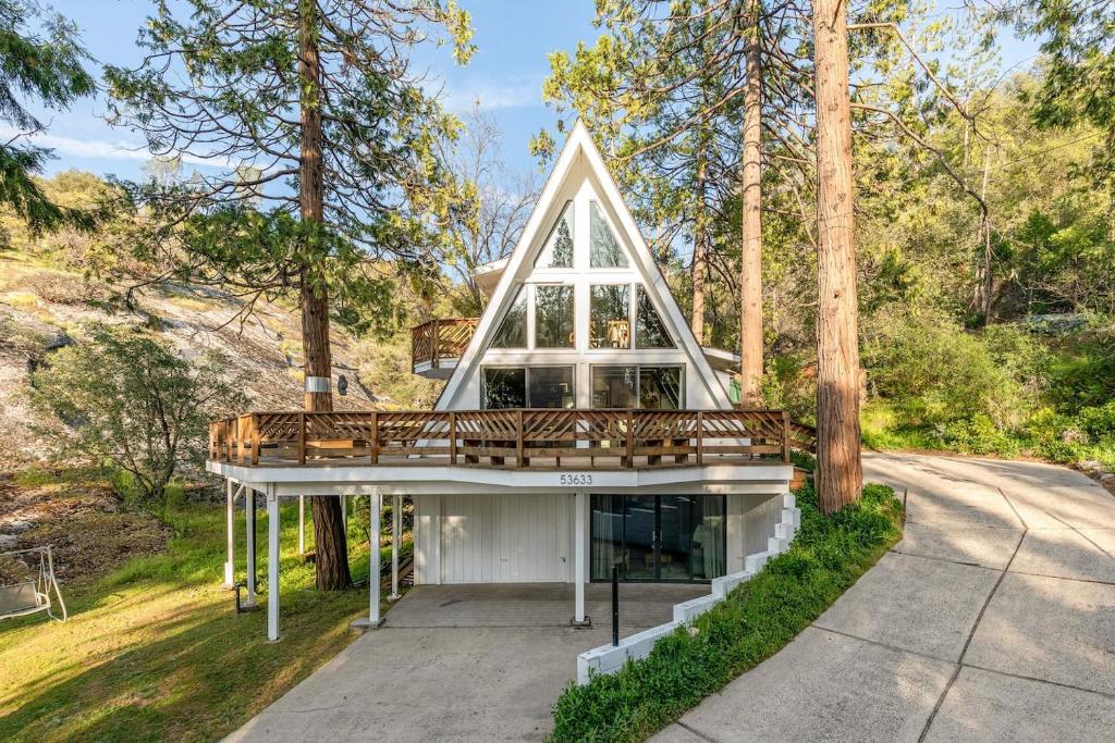 ein Haus mit einem Walmdach und einer Terrasse in der Unterkunft Acorn Falls, Bass Lake, Ca in Bass Lake