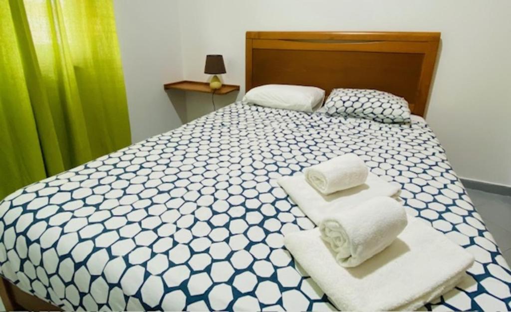a bedroom with a bed with towels on it at SwordFish Fortress View in Peniche