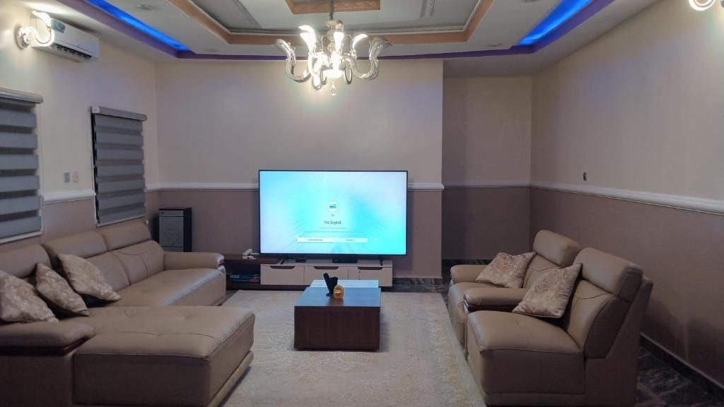 アブジャにあるMiriya Hotel and Apartmentsのソファと薄型テレビのあるリビングルーム