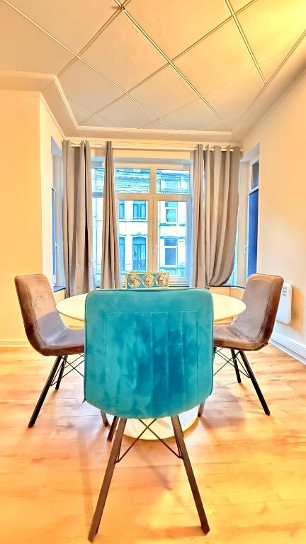 a dining room with a blue table and chairs at Orléan 41 B centre-gare-aéroport in Charleroi