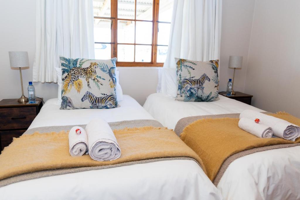 una camera da letto con due letti con asciugamani sopra di Geluk Cottage a Somerset East
