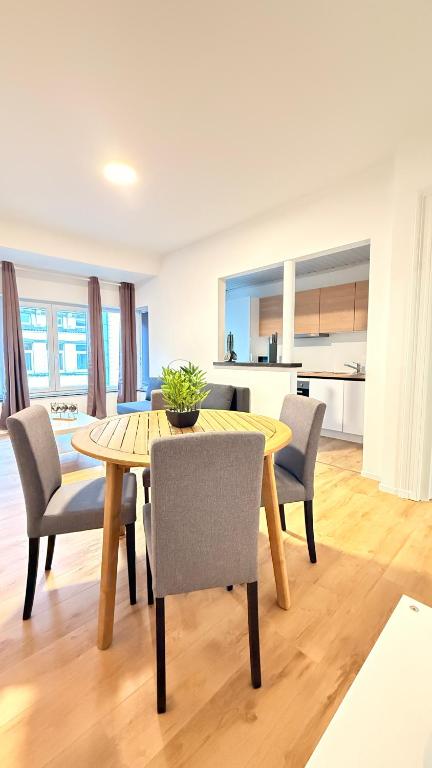 a dining room with a table and chairs and a kitchen at Orléan 41 C centre-gare-aéroport in Charleroi