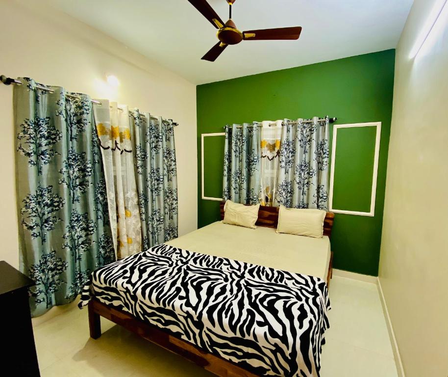 a bedroom with a zebra print bed and green walls at AL MANAL K-002 Premium 2BHK Retreat in Bhatkal